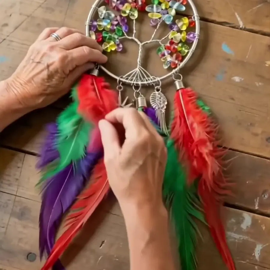 Hands adding colorful decorative details and feathers
