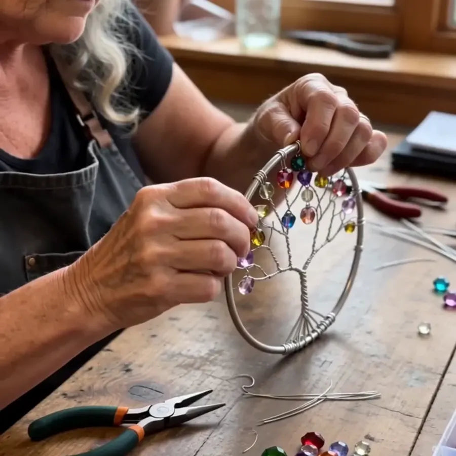 Elderly woman carefully shaping the wire Tree of Life design