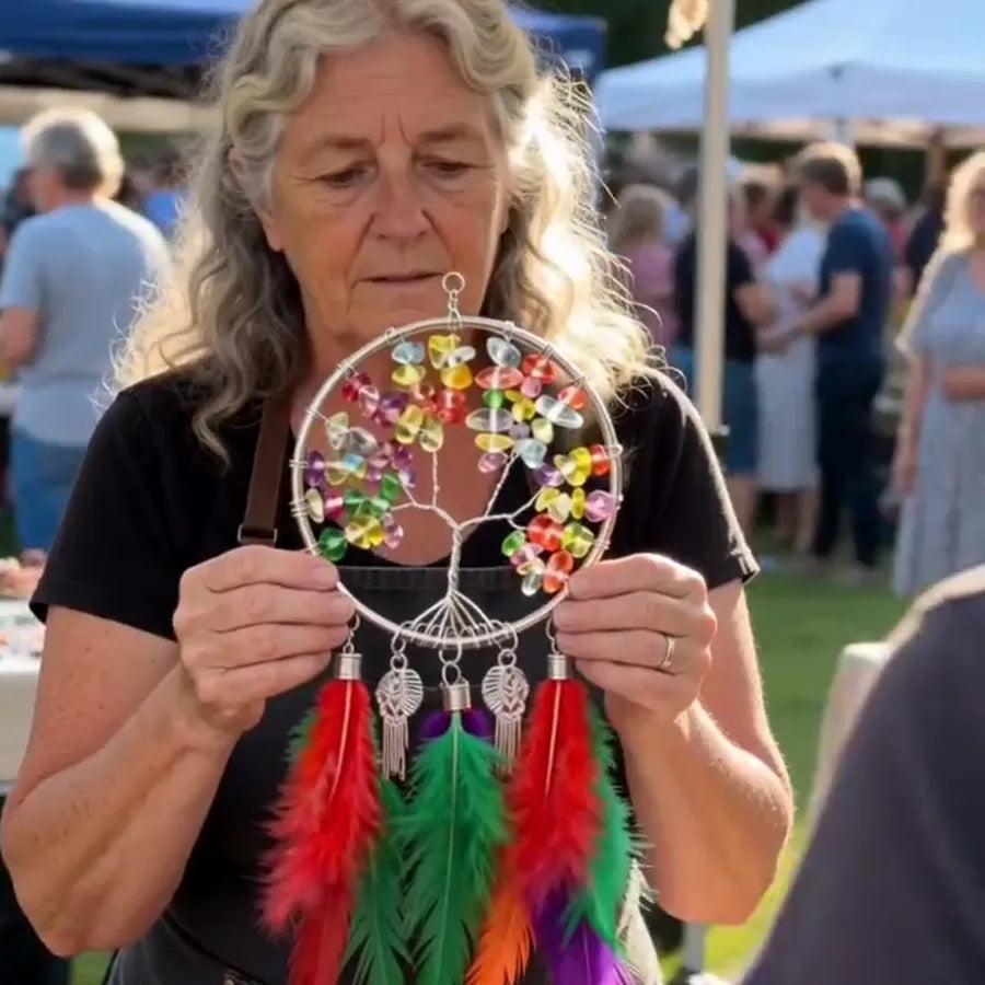 Elderly woman holding the colorful Tree of Life feather hanging